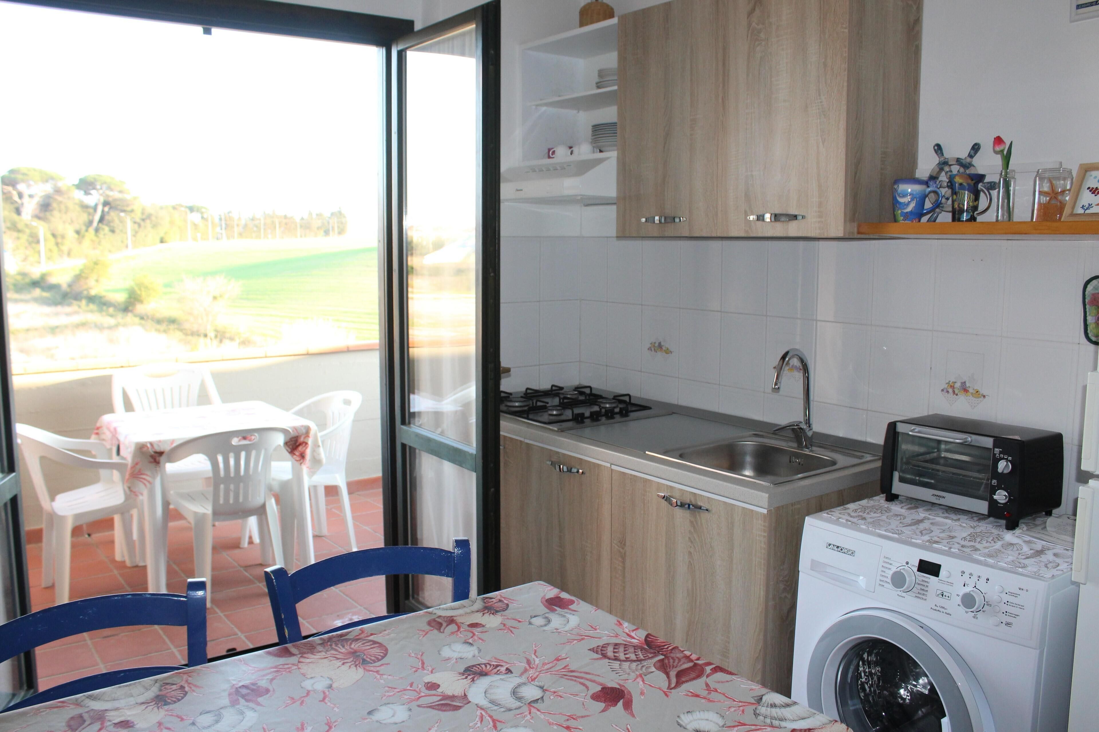 A kitchen with a washing machine, a toaster, and a sink.
