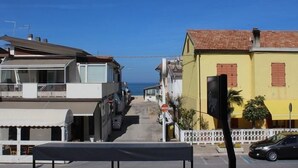 A coastal street with buildings, a clear sky, and a view of the sea. - Four-room apartment 30 meters from the sea, with parking space (Marcelli)