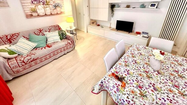 A living room with a sofa, dining table, and kitchen area. - Brand new one-bedroom apartment in downtown with 2 bathrooms and WI-FI (Numana)