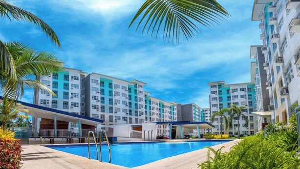 Um hotel com piscina, várias varandas e um design arquitetônico moderno.