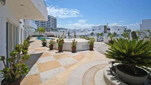 A rooftop terrace with a pool, potted plants, and modern buildings in the background. - Oceanview Balcony, BBQ Lounge, Near Malecon (La Paz)