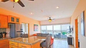 A modern kitchen with granite countertops, stainless steel appliances, and a dining area with a large island. - Oceanview Balcony, BBQ Lounge, Near Malecon (La Paz)