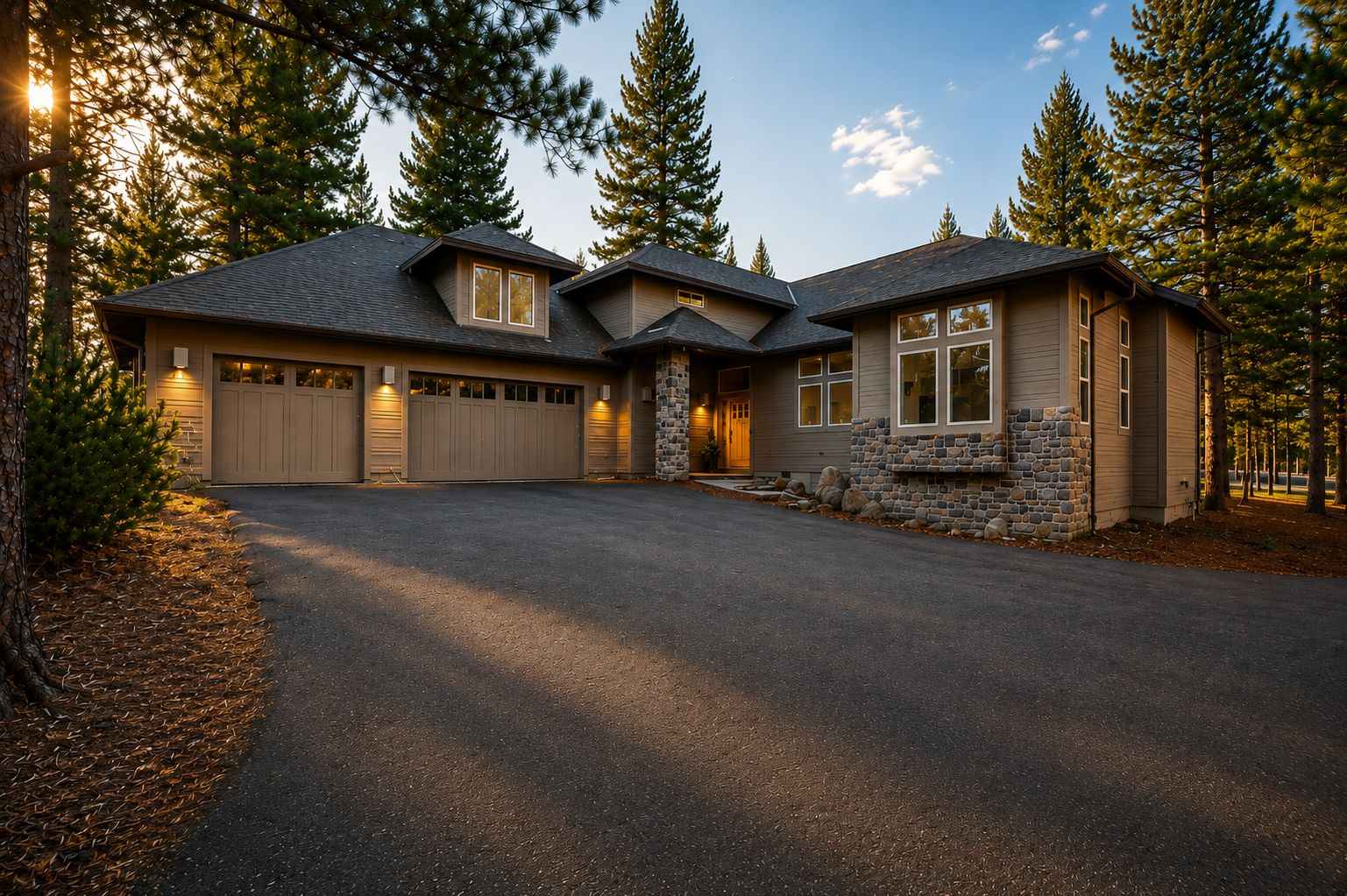 Une maison à deux étages avec une façade en pierre, un garage et une allée.