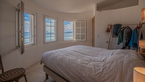 Una camera da letto con un letto, una sedia e un appendiabiti.