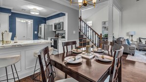 A modern kitchen with white cabinets, a built-in microwave, and a stainless steel refrigerator. - Centrally Located Retreat (Indianapolis)