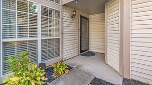 A house with a covered porch, a door, and a small garden area. - Centrally Located Retreat (Indianapolis)