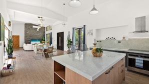 Een ruime keuken met een groot kookeiland, moderne apparatuur en een eethoek met uitzicht.