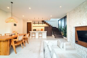 Een modern interieur met een eethoek, keuken, trap en woonkamer.