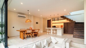 A modern interior with a dining area, kitchen, and staircase. - La Finca Villa Bingin, Uluwatu by Sandara (Pecatu)