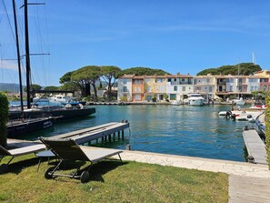 A marina with boats, a wooden dock, and a row of colorful buildings. - Exceptional 165 m2 house with double mooring 16 m (PORT GRIMAUD)