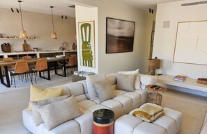 A modern living room with a sofa, a dining area with chairs, and artwork on the walls. - Exceptional 165 m2 house with double mooring 16 m (PORT GRIMAUD)