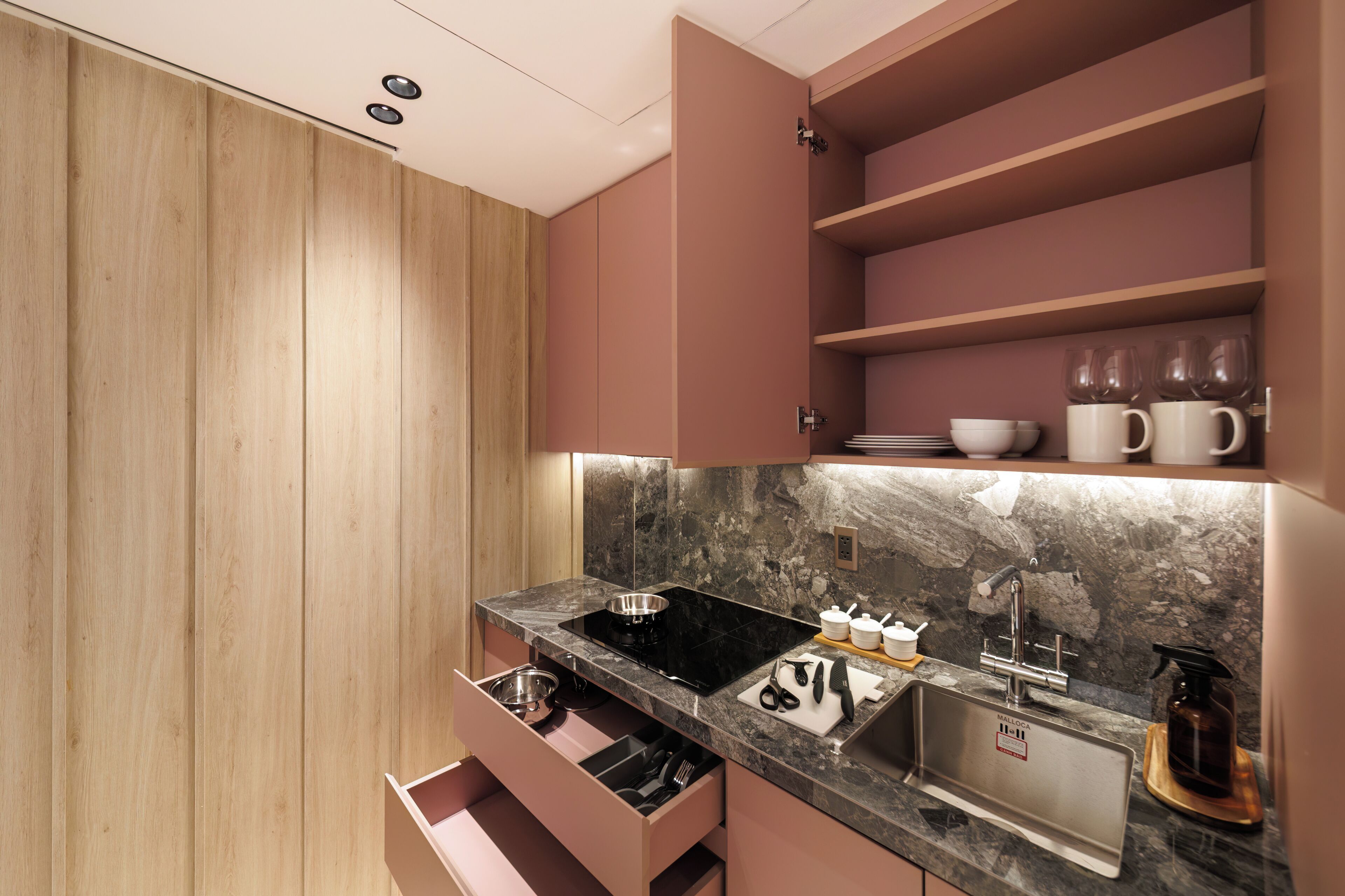 Una cocina moderna con armarios de madera, salpicadero de mármol y electrodomésticos de acero inoxidable.