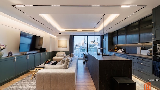 A modern kitchen with a large island, dark cabinets, and a city view. - A HOUSE SAIGON (Ho Chi Minh City)
