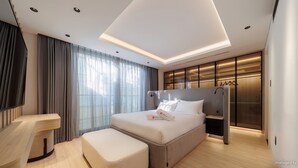 A modern hotel room with a bed, a desk, a chair, and a large window with curtains. - A HOUSE SAIGON (Ho Chi Minh City)