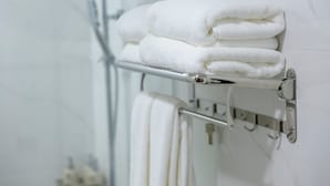Ein Badezimmer mit Handtuchhalter und gefalteten Handtüchern.