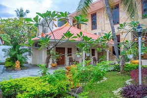 A traditional house with a tiled roof, surrounded by lush greenery and a well-maintained garden. - Grand Melka Hotel (Buleleng)