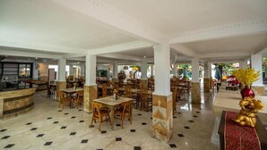 A spacious hotel lobby with multiple dining areas, a reception desk, and a pool area. - Grand Melka Hotel (Buleleng)