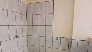 Une salle de bain comprenant un lavabo, des toilettes et un espace douche.