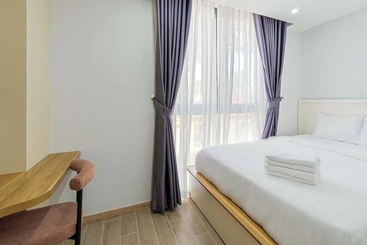 Una habitación de hotel con una cama, un escritorio y una silla.