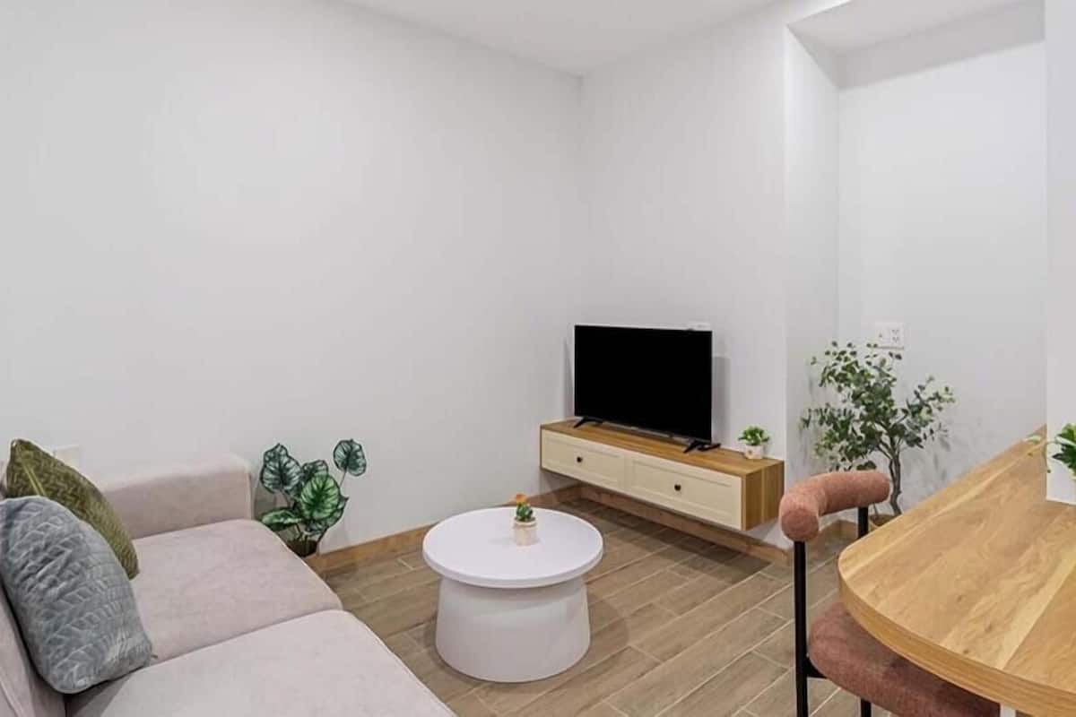 Una sala de estar moderna con un sofá, una mesa de centro, un televisor y un comedor.