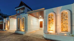 A modern house with arched windows and a covered walkway. - Ghania Villas Melasti (Ungasan)