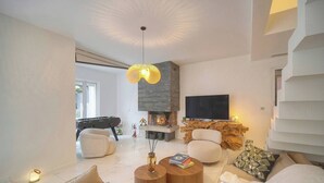 A modern living room with a fireplace, sofa, coffee table, and a flat-screen TV. - 13491130 FRGK French Riviera Villa with Private Pool AC (Cannes)