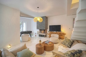 Ein modernes Wohnzimmer mit Kamin, Sofa, Couchtisch und Flachbildfernseher.