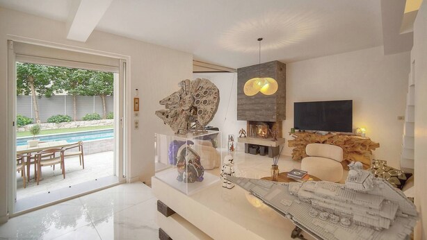 A modern living room with a glass door leading to a pool, a fireplace, and Star Wars collectibles. - 13491130 FRGK French Riviera Villa with Private Pool AC (Cannes)