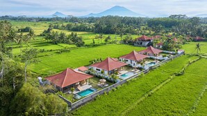 A resort with multiple villas, a swimming pool, and lush green fields. - Uma Dawa Residence (Ubud)