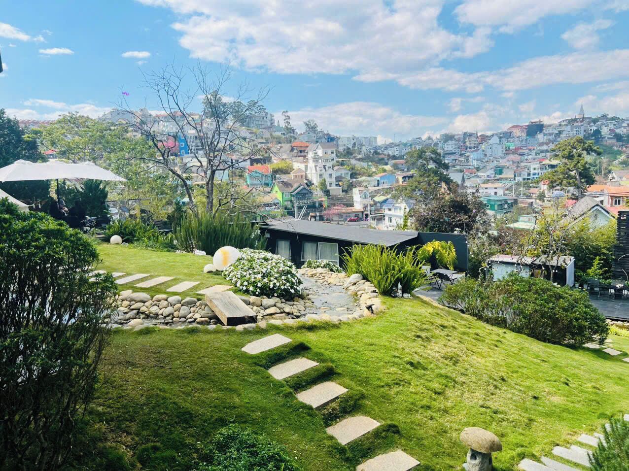 Zona residencial con césped, un camino de piedra y un pequeño estanque.