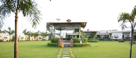 A pathway leading to a covered area with a building in the background.