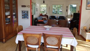 A dining area with a table, chairs, a cabinet, and a television. - Bed and breakfast La Villa Stella in Arcachon with swimming pool (La Teste-de-Buch)