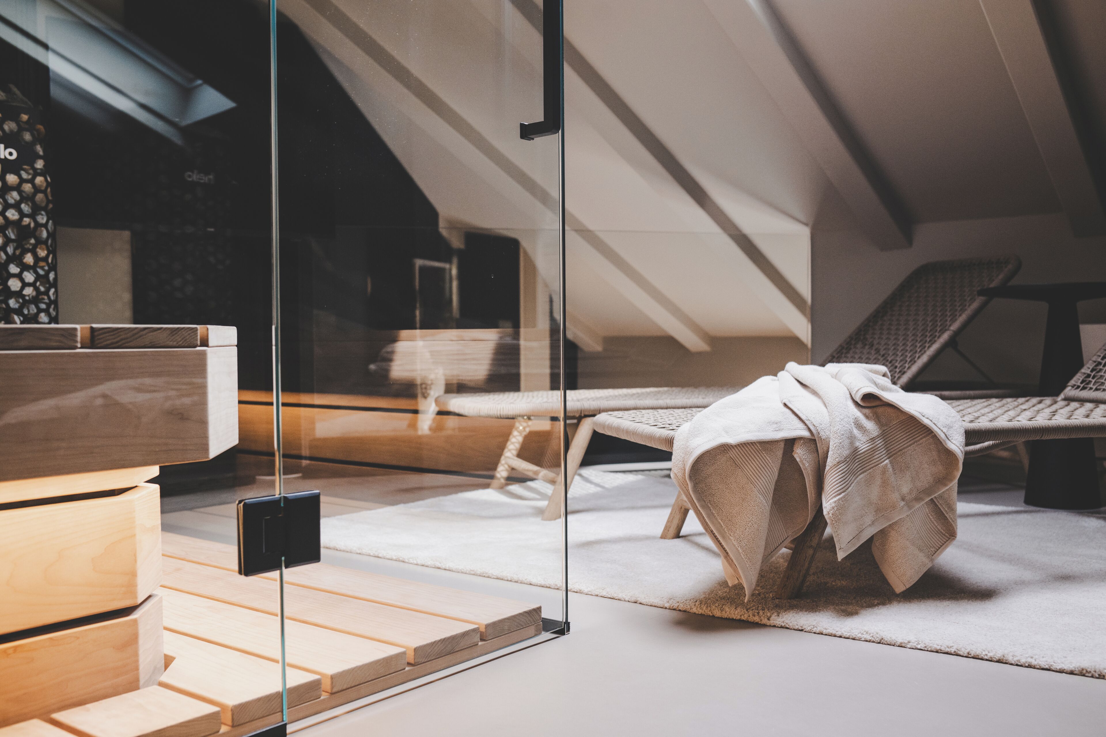 Un dormitorio tipo loft moderno con pared de vidrio, muebles de madera y vistas al exterior.