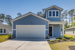 A single-story house with a garage, a second-story attic, and a small porch.