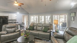 A living room with a sofa, coffee table, and ceiling fans.
