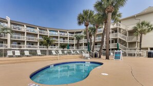 Un hotel con piscina, diversi balconi e palme.