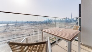 Un balcon donnant sur le panorama urbain, avec une table et une chaise.