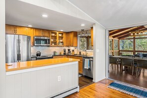 Una cocina moderna con armarios de madera, electrodomésticos de acero inoxidable y una isla de madera.