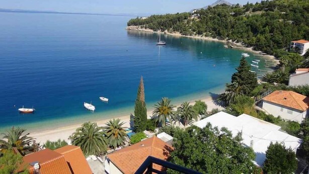 A coastal view with a clear sea, boats, and a hilly landscape with buildings. - Studio with shared pool (Stanići)