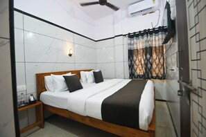 Een slaapkamer met een bed, nachtkastje en een raam met gordijnen.