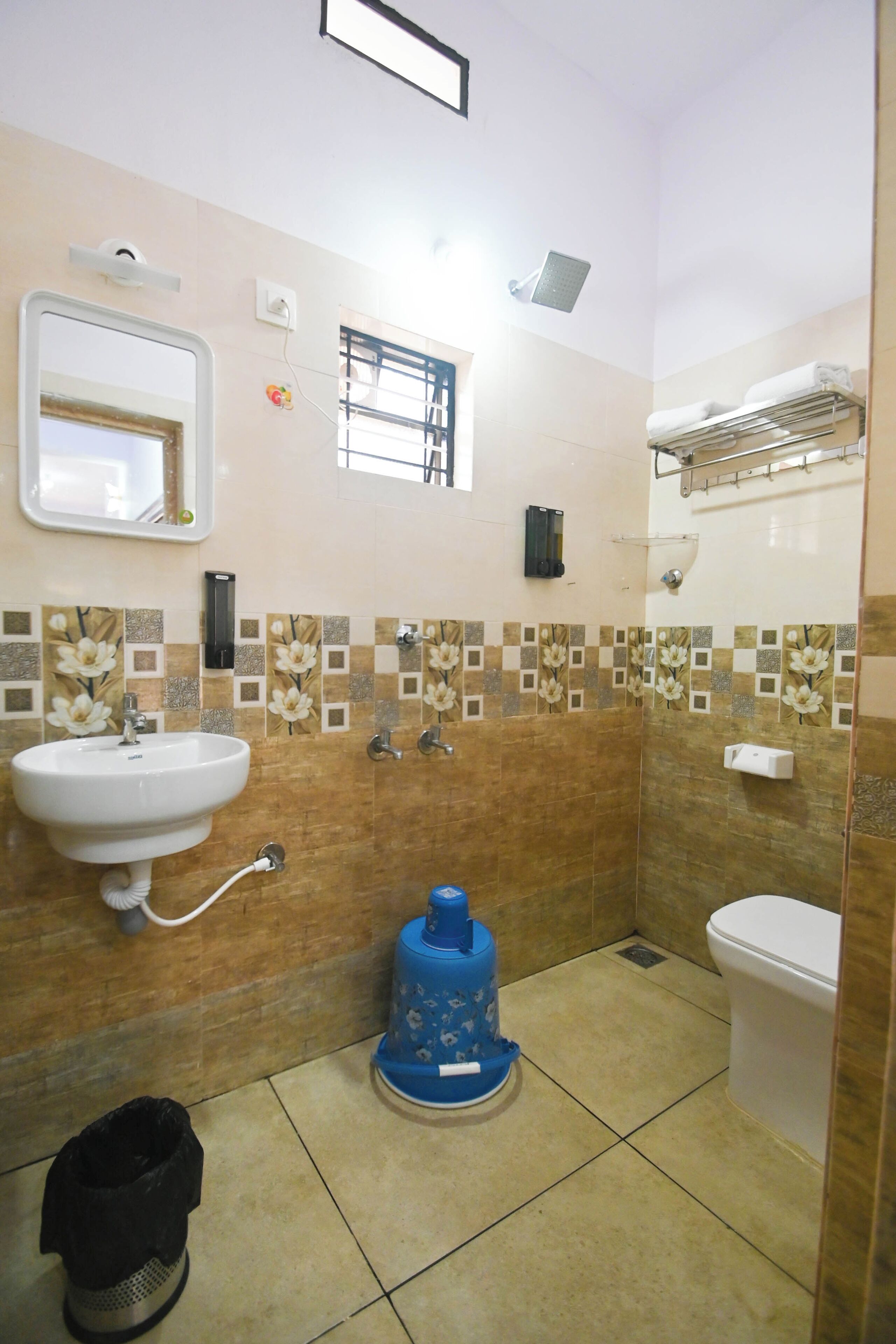 Un baño con lavamanos, inodoro y dispensador de agua azul.