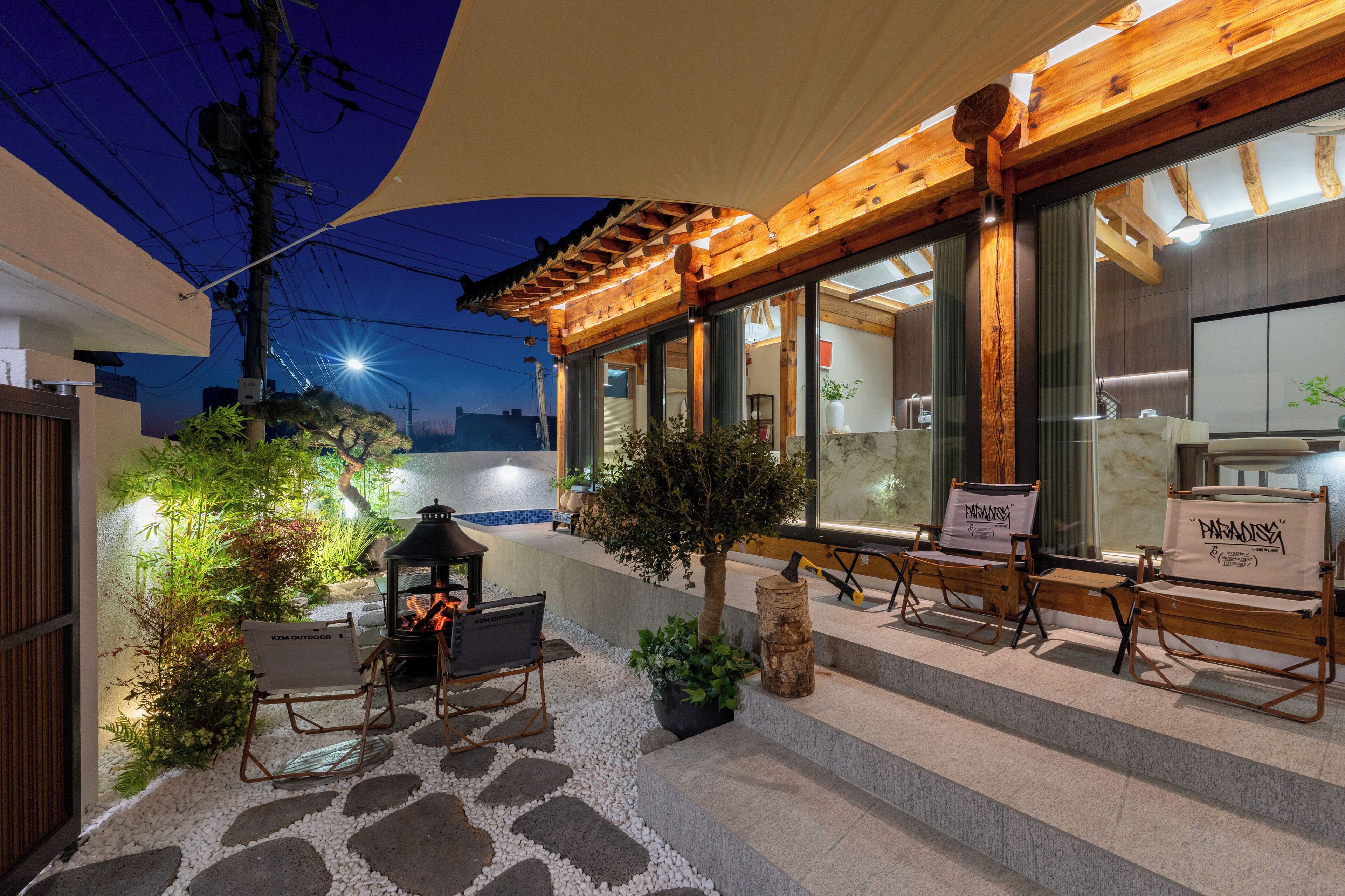 Un pati amb mobiliari exterior, una llar de foc i una estructura de pergola.