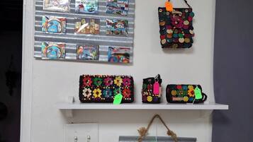 Una pared con varios elementos con temática de Panamá, incluyendo un panel metálico con postales, un bolso colorido y un estante con adornos.
