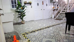 A hallway with a tiled floor, white doors, a potted plant, and a staircase. - Apartamento Lilia Airport 1 (Panamá)