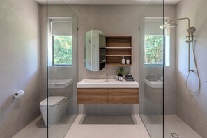 A modern bathroom with a glass shower enclosure, a wooden vanity, and a large mirror. - NEW Alcheringa - Private Estate (Hamilton Island)