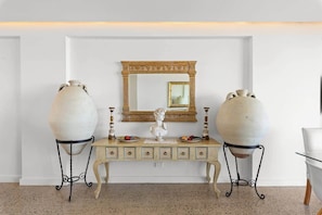 A white console table with a mirror above it, flanked by two large vases on metal stands. - Breathtaking Ocean View Tamarama Beachfront (Tamarama)