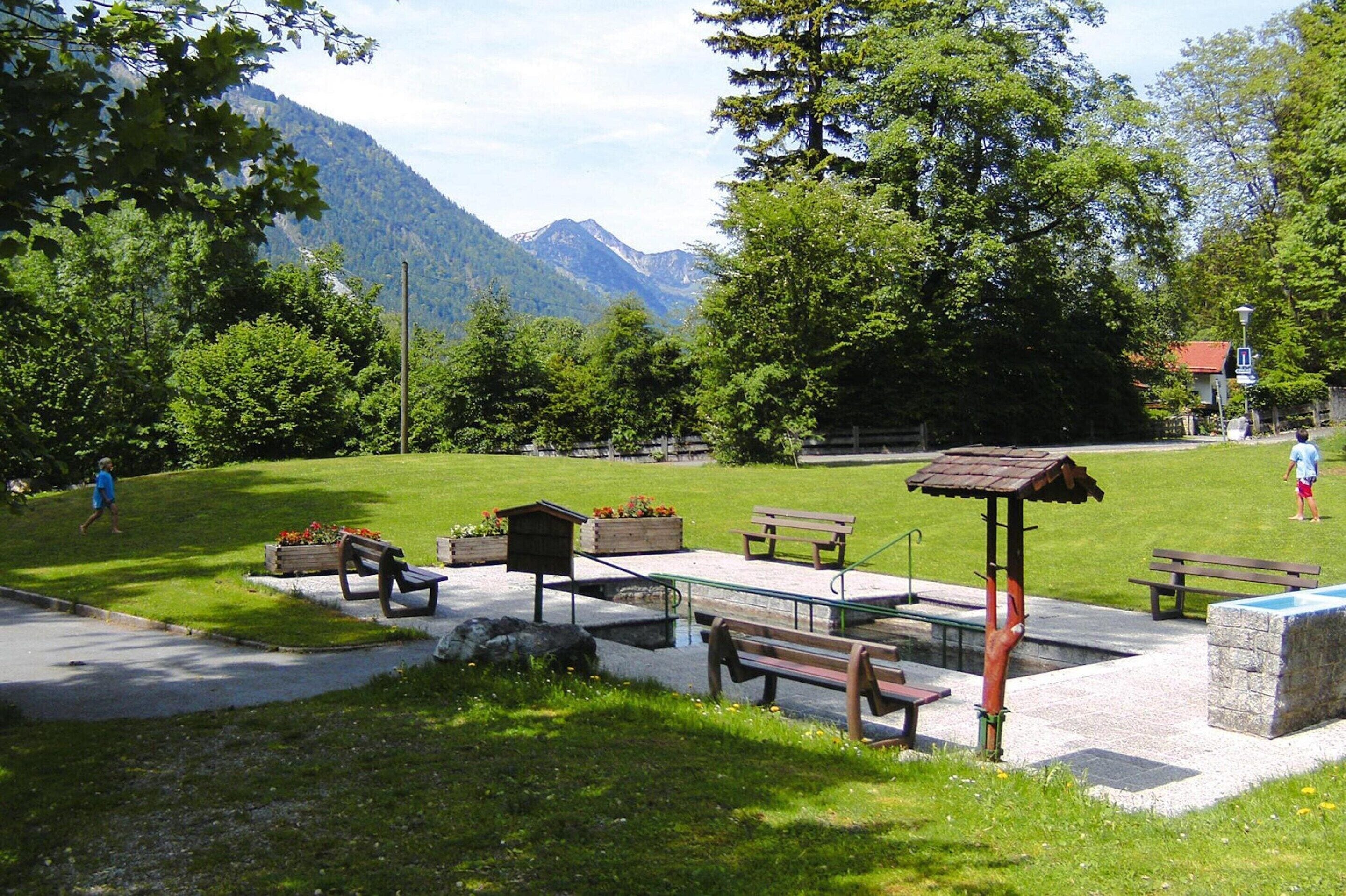 Ein Park mit Bänken, einem Pavillon und einem Spielplatz.