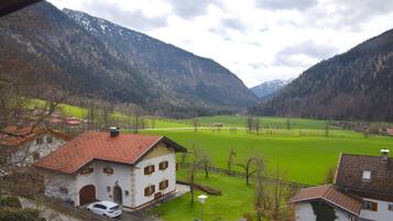 Ein Landhaus mit rotem Ziegeldach, weißem Anstrich und einem grünen Feld im Hintergrund.