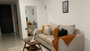 A modern living room with a sofa, coffee table, and a bed. - Studio Apartment with a pool in Ruaka (Ruaka)