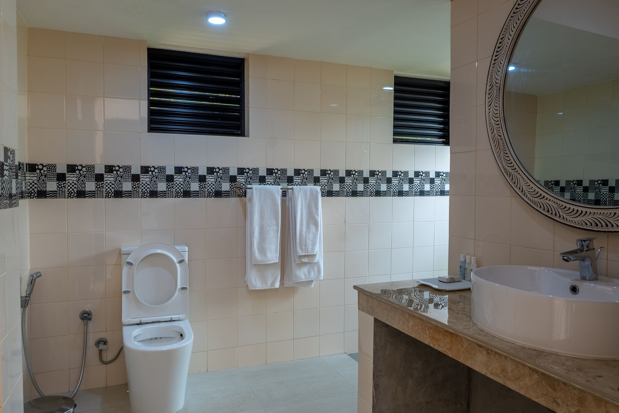 A bathroom with a toilet, sink, and towel rack.